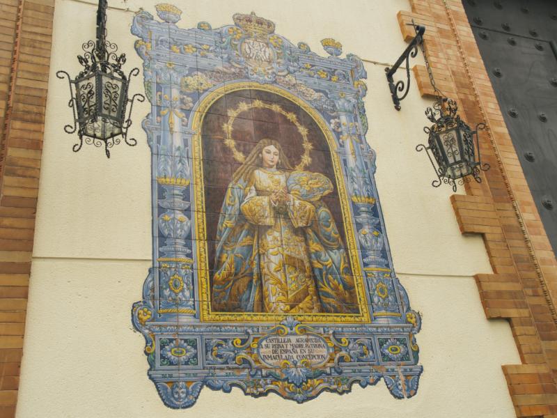 Azulejo multicolor con dos faroles a cada lado de la imagen de la virgen de la Inmaculada Concepción en la fachada de la iglesia de la Calle Real, como comúnmente de la conoce.