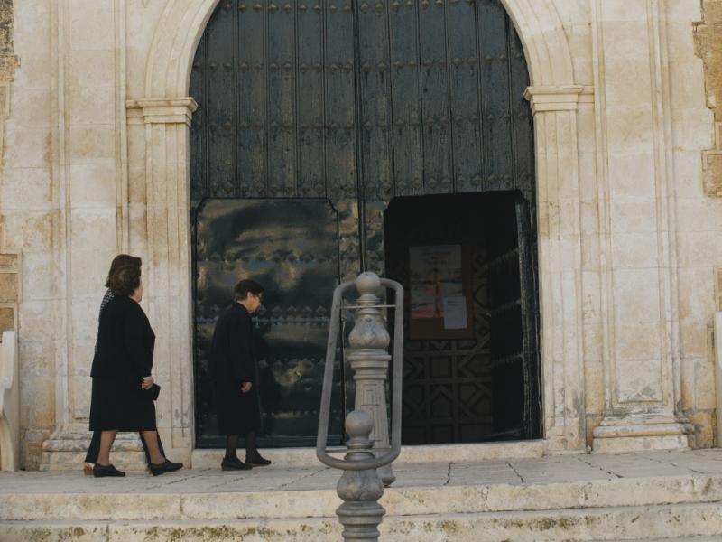 Puerta principal de la iglesia y fieles entrando