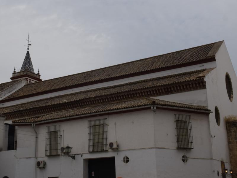 Imagen del edificio completo de la iglesia de san julián donde asoma la torre por detrás de la techumbre de la misma