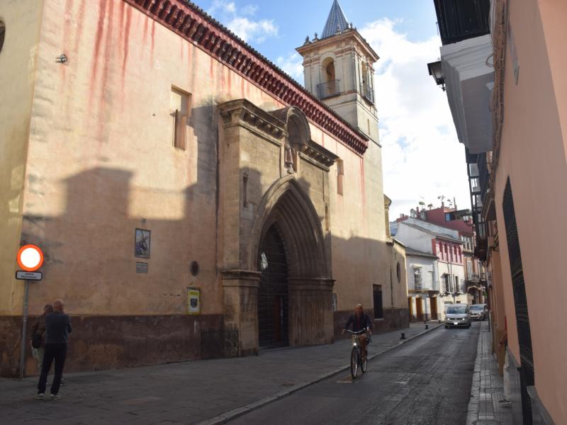 Fachada principal de entrada de la iglesia de san esteban dando a una calle estrecha, al fondo se ve la torre