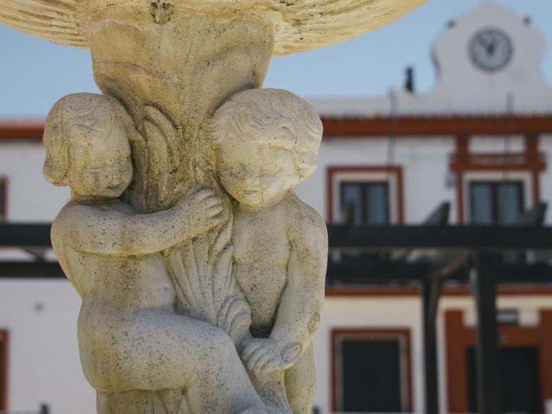 El Garrobo. Detalle de esculturas en fuente con el Ayuntamiento detrás
