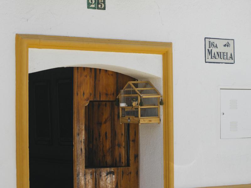 El Ronquillo. Casa rural blanca con detalles en azul y amarillo