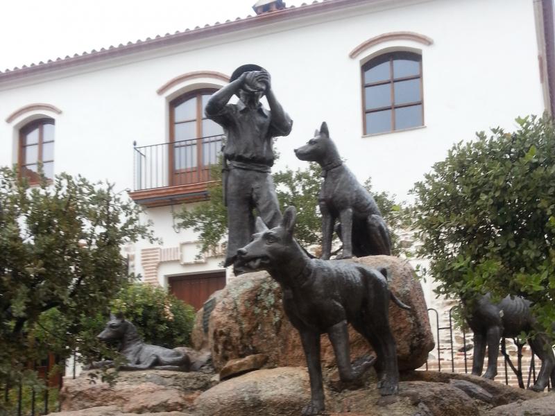 Almadén de la Plata. Monumento al Rehalero, rehalero rodeado de 4 perros