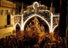 Cantillana. Procesión nocturna de la Virgen de Nuestra Señora de la Asunción bajo un arco de luces